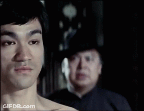 Man Without Shirt In Front Of Man In Hat GIF