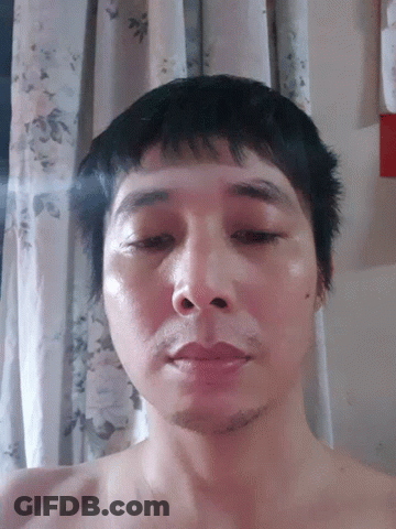 Man Without Shirt Lying Down Looking At Camera GIF