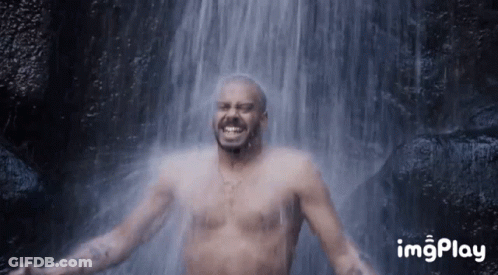 Man Without Shirt Smiling In Front Of Waterfall GIF
