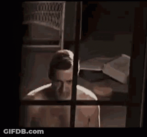 Man Without Shirt Standing By Window GIF