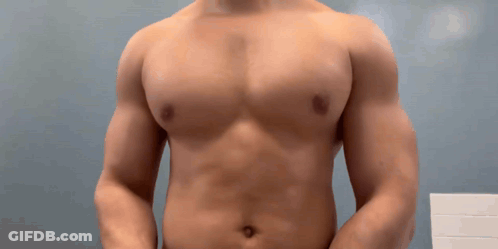 Man Without Shirt Standing In Front Of Blue Wall GIF