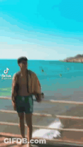 Man Without Shirt Standing On Dock GIF