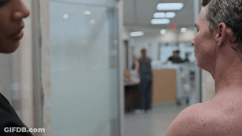 Man Without Shirt Talking To Woman In Hospital Hallway GIF