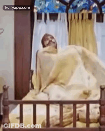 Man Wrapped In Blanket Looking At Camera GIF