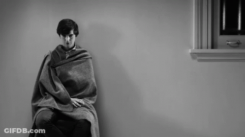Man Wrapped In Blanket Sitting In Chair By Window GIF