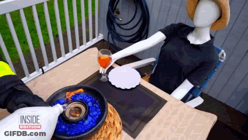 Mannequin At Table With Inside Edition Bottle GIF