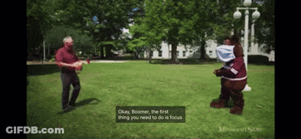 Mascot Costume Talking To Man In Red Shirt GIF