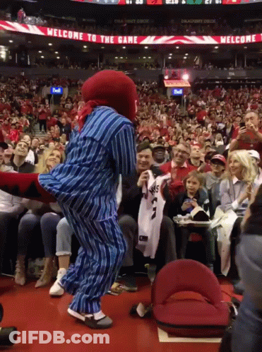 Mascot Dancing In Front Of Welcome Sign GIF