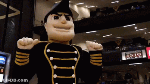 Mascot In Black And Gold Uniform In Front Of 1510 WLAC Sign GIF