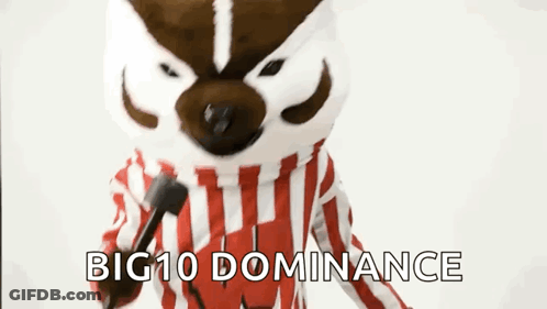 Mascot In Red And White Striped Shirt Holding Microphone Saying Big 10 Dominance GIF