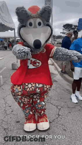 Mascot In Red Shirt And Floral Pants Standing On Street GIF