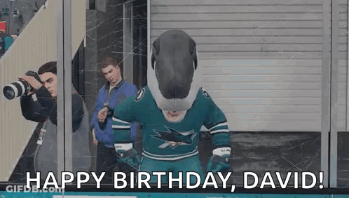 Mascot In Shark Jersey Standing In Front Of Glass Wall GIF