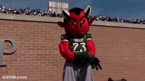 Mascot In Valley 23 Jersey In Front Of Brick Wall GIF