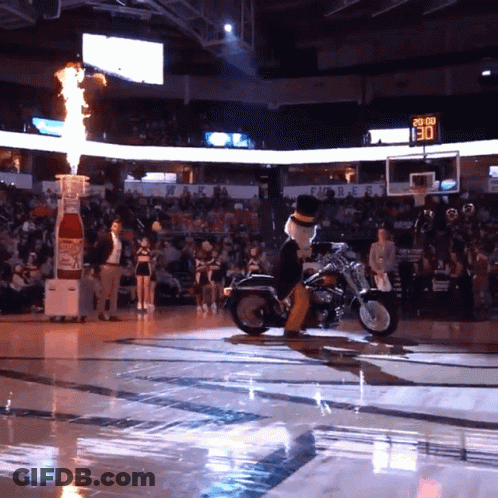 Mascot Riding Motorcycle On Basketball Court With Scoreboard 130 GIF