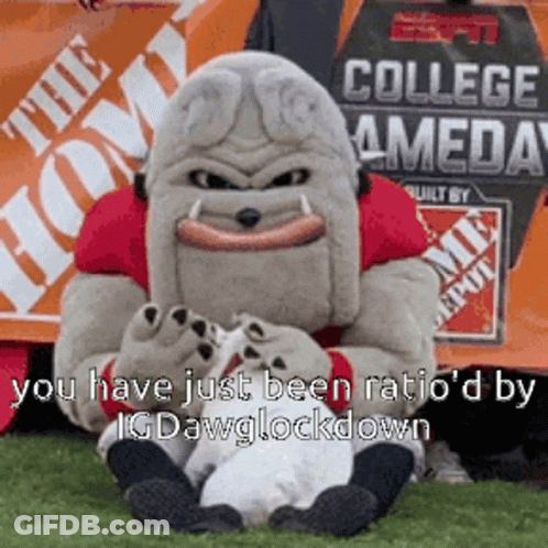 Mascot Sitting On Grass In Front Of Home Depot Sign GIF