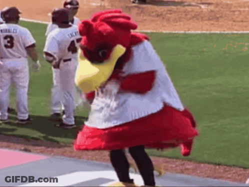 Mascot Standing On Baseball Field With Players Behind GIF