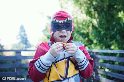 Masked Boy Eating Snack In Red Hoodie GIF