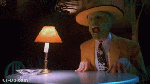 Masked Man At Table With Orange Lamp GIF