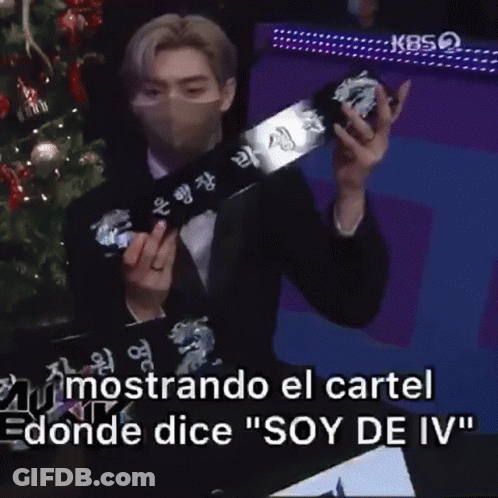 Masked Man Holding Box Christmas Tree Says Soy De Iv GIF