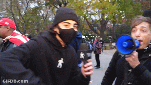 Masked Man Holding Microphone Woman Shouting Into Megaphone GIF