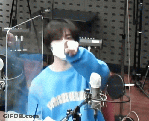 Masked Man In Blue Sweater At Microphone GIF