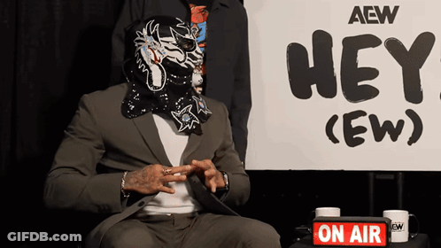 Masked Man In Front Of Sign Saying Hey GIF