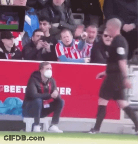 Masked Man Kneeling Before Referee On Soccer Field GIF