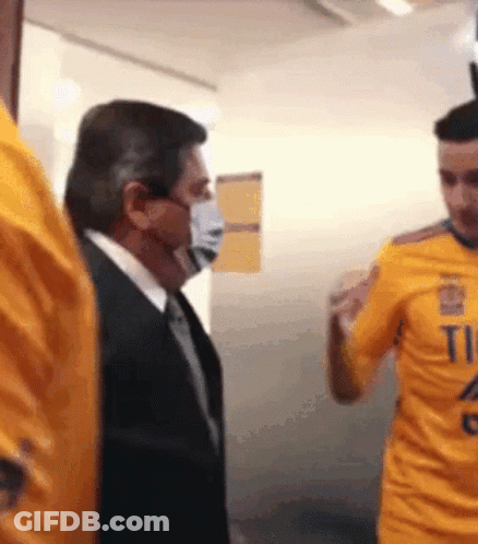 Masked Man Next To Man In Yellow Shirt Number 11 GIF