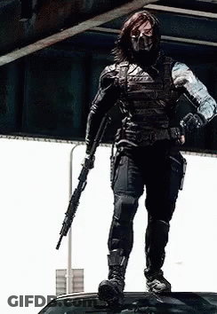 Masked Man On Car Roof Holding Gun GIF