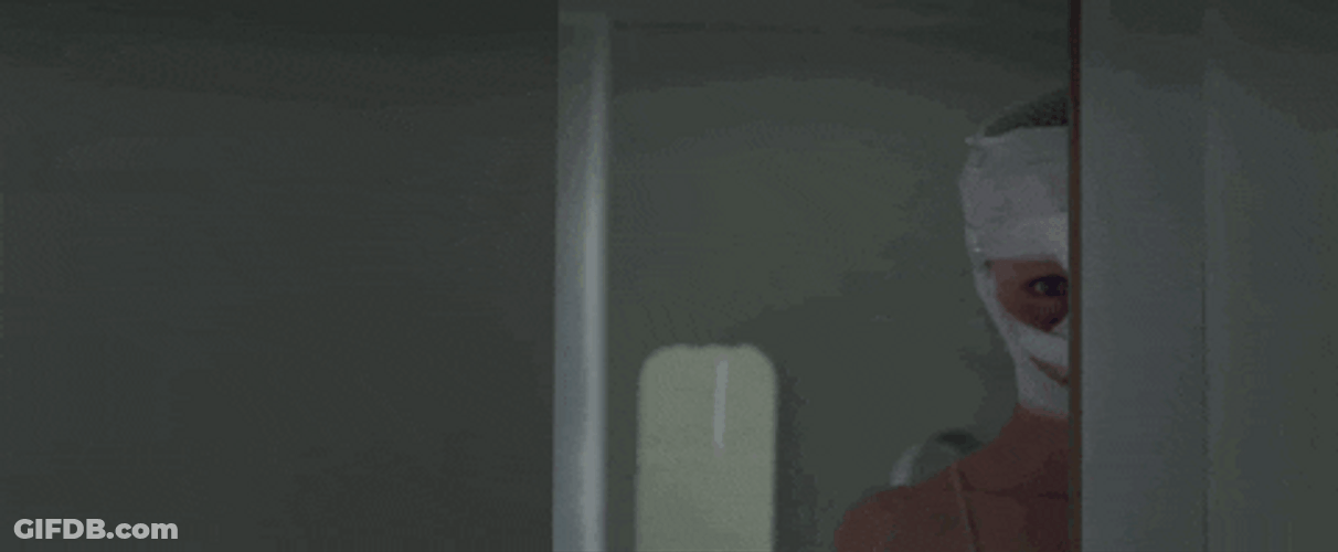 Masked Man Stalking Behind Wall GIF