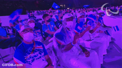 Masked People Sitting In Purple Lit Stadium GIF