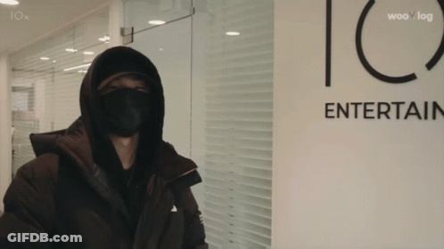 Masked Person In Front Of Iox Entertainment Sign GIF