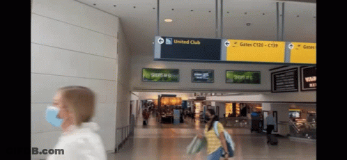Masked Woman At Airport Holding United Club Sign GIF