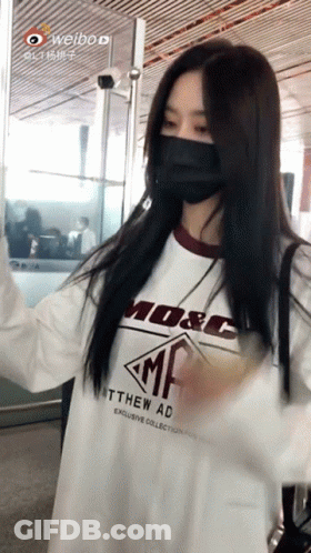 Masked Woman In White Shirt With M & C GIF