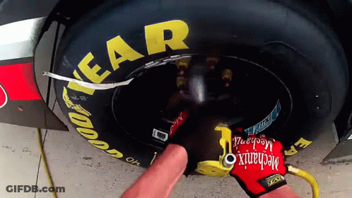 Mechanic Wearing Red Glove Working On Race Car Tire GIF