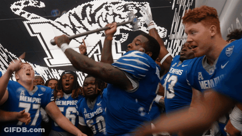 Memphis Football Players Holding Stick In Air GIF