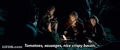 Men Around Campfire Eating Tomatoes Sausages Bacon GIF