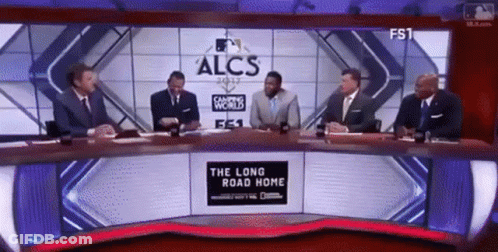 Men At Table In Front Of Sign Saying The Long Road Home GIF