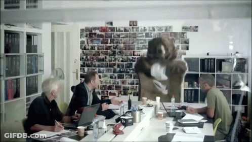 Men At Table With Papers Laptops And Picture Wall GIF