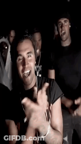 Men Dancing In Dark Room One Smiling And Clapping GIF