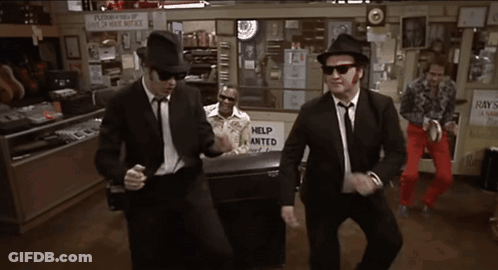 Men Dancing In Front Of Help Wanted Sign GIF