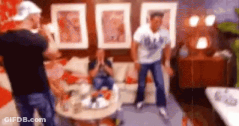 Men Dancing In Living Room While Woman Sits On Couch GIF