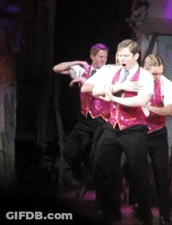 Men Dancing In Red Vests On Stage GIF