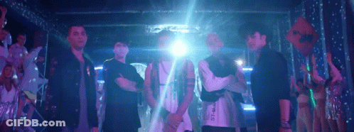 Men Dancing On Stage In Front Of Devil's Building GIF