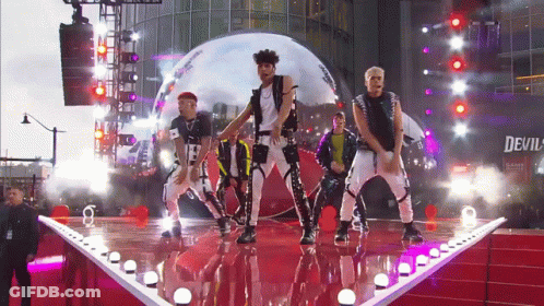 Men Dancing On Stage Under Devil Sign GIF