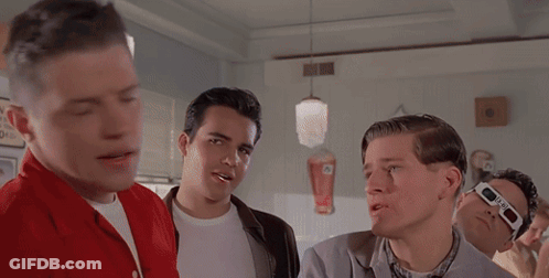 Men Gathered Around Diner Table With Behind Sign GIF