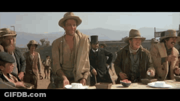 Men Gathered Around Table With Motel Sign GIF