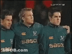 Men In Black Adidas Shirts Standing In Line GIF