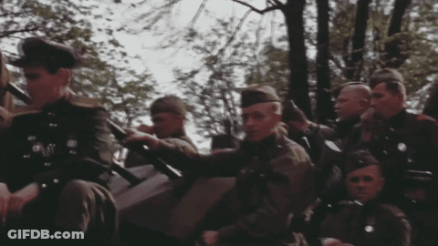 Men In Military Uniforms Sitting In Field GIF