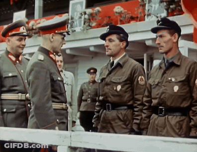 Men In Military Uniforms Standing In Front Of Railing GIF